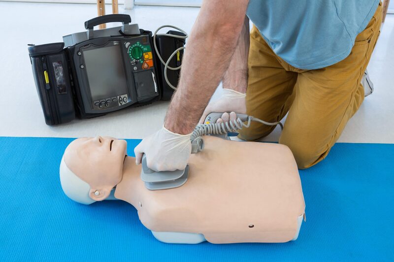 Paramedic practicing resuscitation on dummy in clinic